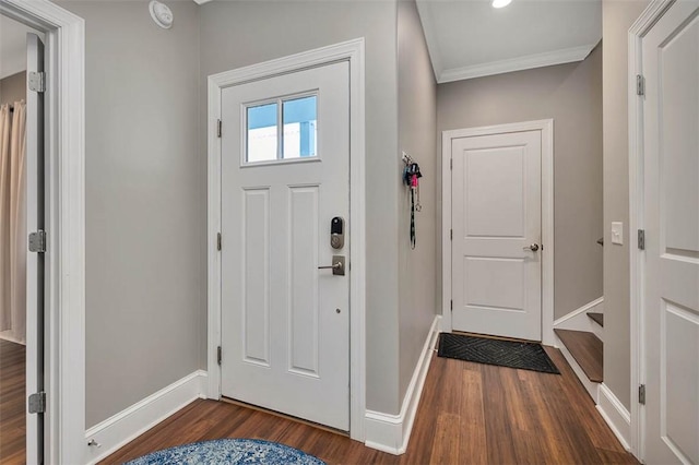 entrance foyer with dark wood-style flooring, crown molding, and baseboards