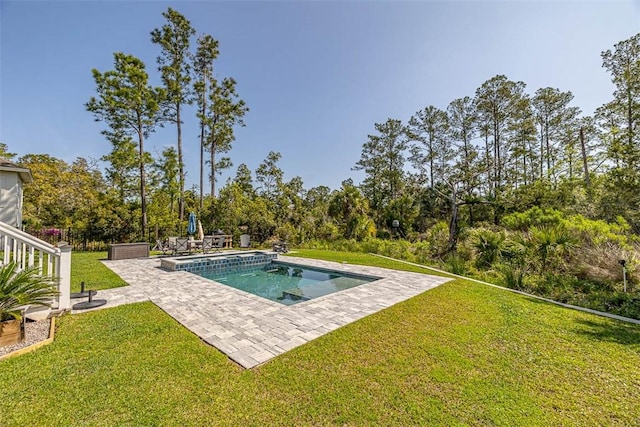 pool featuring a patio, fence, and a lawn