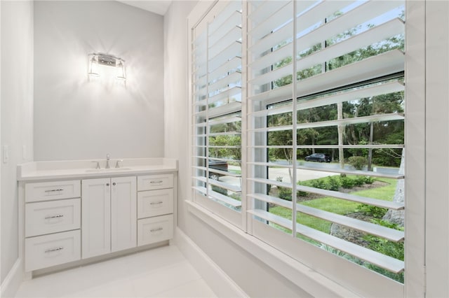 bathroom featuring tile patterned flooring, vanity, and a healthy amount of sunlight