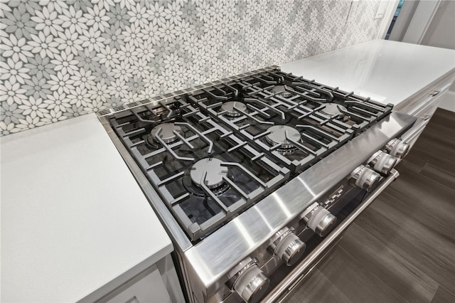 interior details featuring stainless steel cooktop, dark hardwood / wood-style floors, and tasteful backsplash