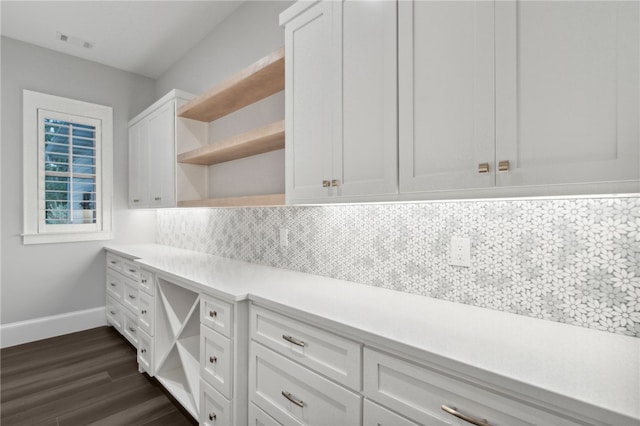 kitchen with tasteful backsplash, white cabinetry, and dark hardwood / wood-style floors