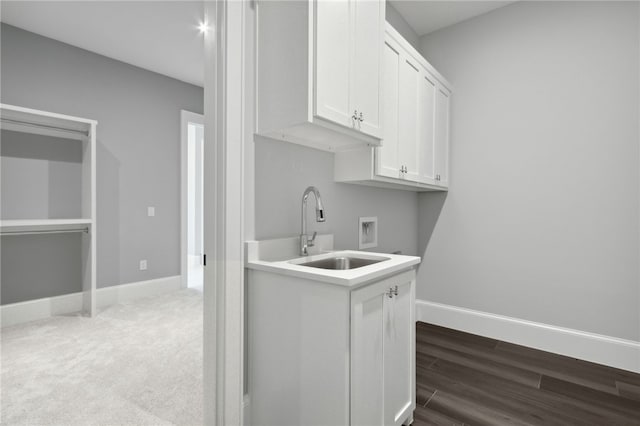 washroom with hardwood / wood-style flooring, cabinets, sink, and hookup for a washing machine