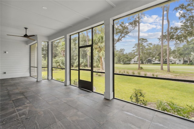 unfurnished sunroom with ceiling fan