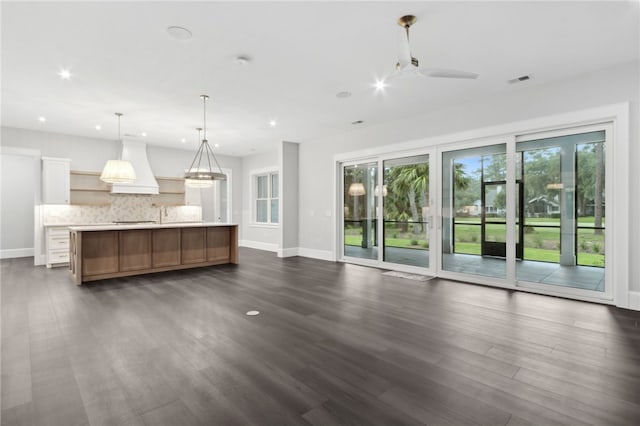 unfurnished living room featuring dark hardwood / wood-style flooring and ceiling fan