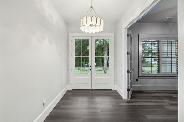 entryway with a notable chandelier, dark hardwood / wood-style floors, and french doors