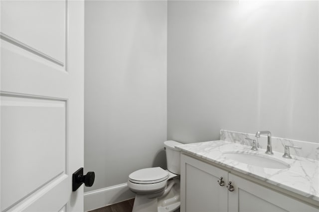 bathroom featuring hardwood / wood-style flooring, vanity, and toilet