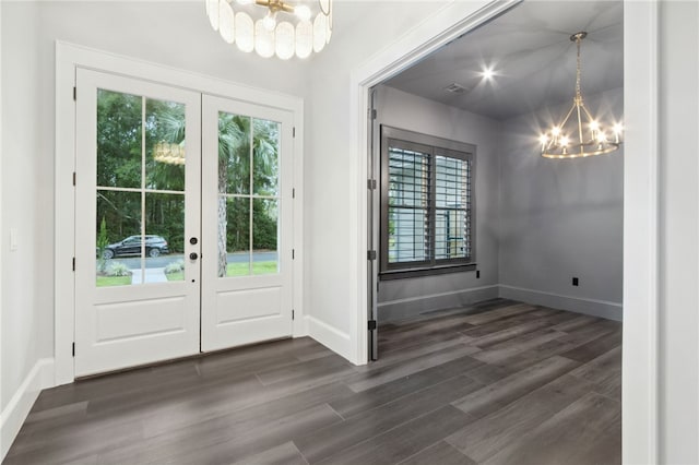 doorway with dark hardwood / wood-style flooring, french doors, and a chandelier