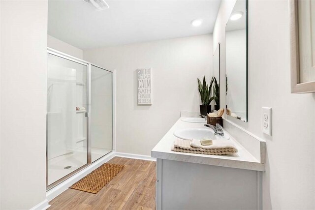 bathroom with hardwood / wood-style floors, vanity, and walk in shower