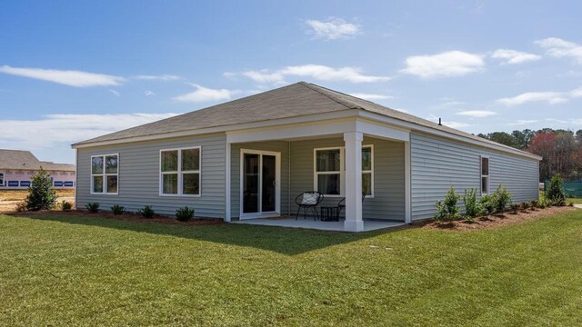 rear view of property featuring a yard and a patio area