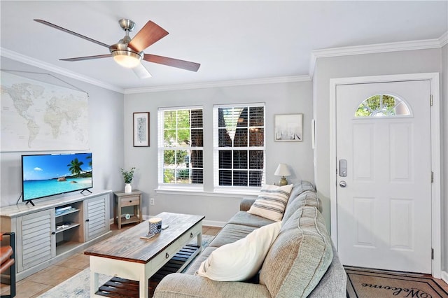 living area featuring ceiling fan, a wealth of natural light, ornamental molding, and light tile patterned floors