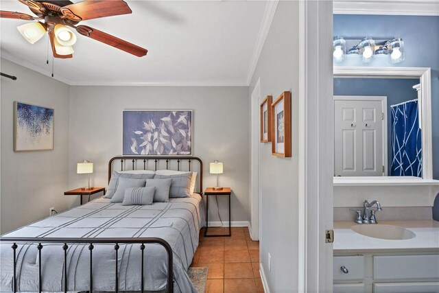 bedroom featuring a ceiling fan, crown molding, a sink, tile patterned floors, and baseboards