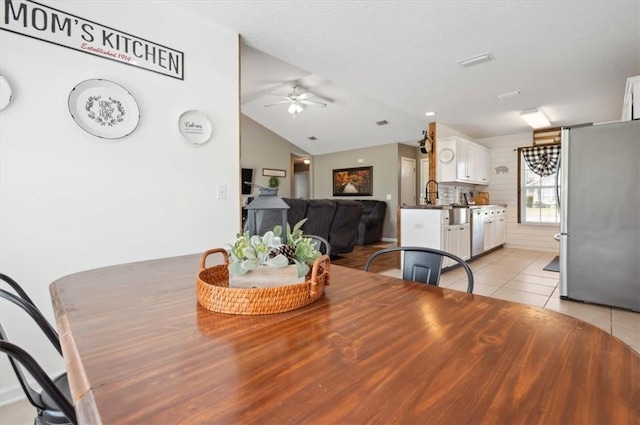 tiled dining room featuring ceiling fan and lofted ceiling