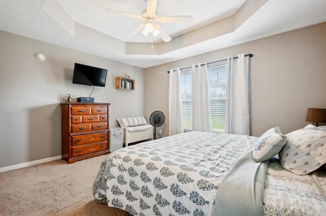 bedroom with carpet, a raised ceiling, and ceiling fan