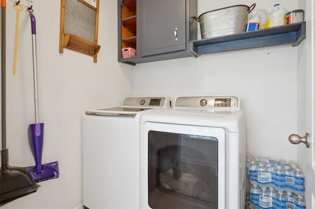 washroom with separate washer and dryer and cabinets