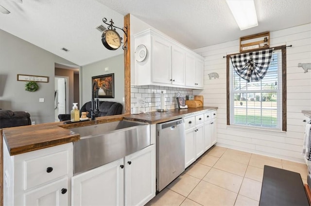 kitchen with wooden walls, dishwasher, and white cabinets