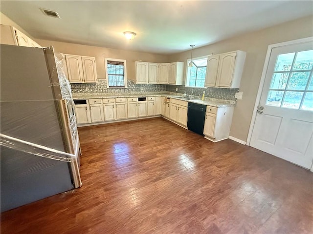 2292 Park Ave, Waycross, GA 31503 - kitchen featuring freestanding refrigerator, black dishwasher, healthy amount of natural light, and dark wood-type flooring