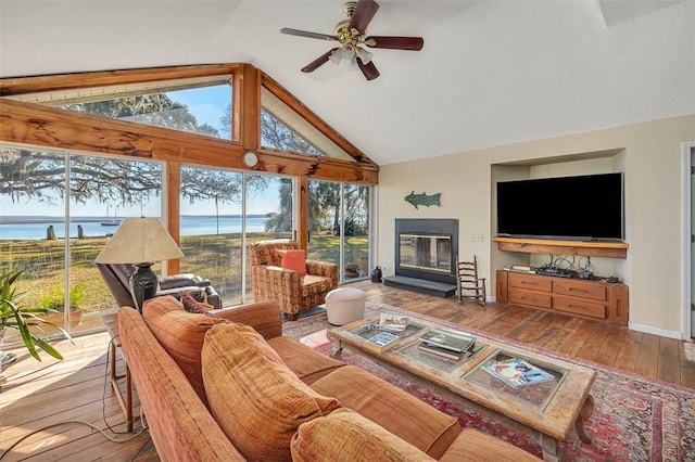 sunroom with vaulted ceiling, a water view, and ceiling fan