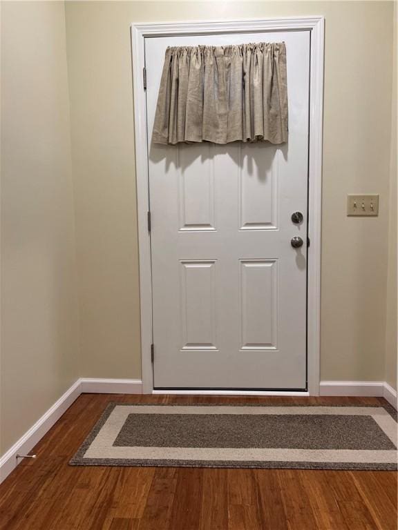 doorway to outside with wood finished floors and baseboards