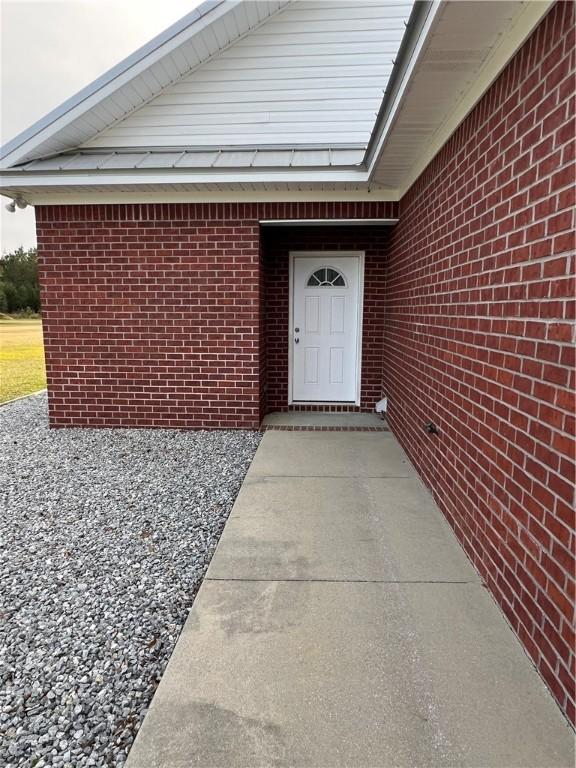 doorway to property featuring brick siding