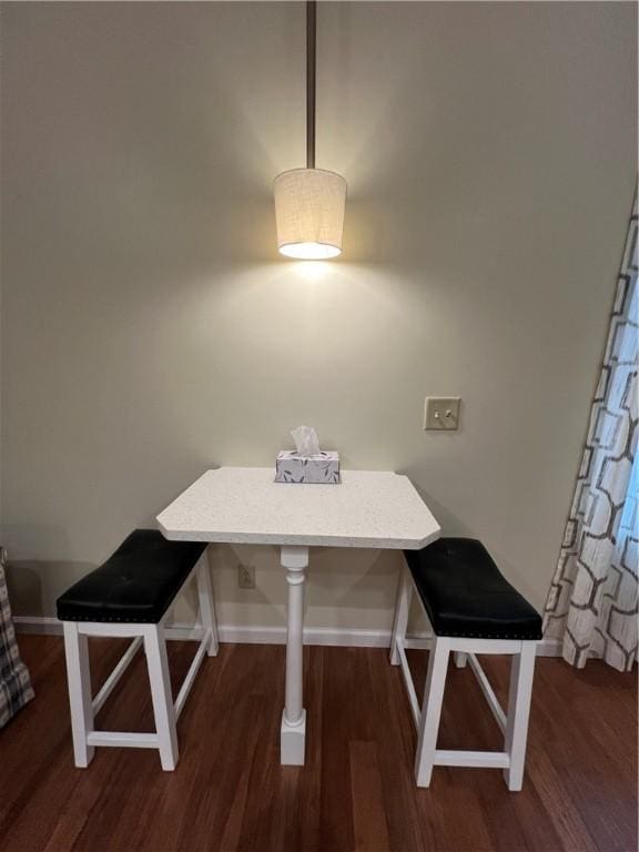 dining room featuring breakfast area, baseboards, and wood finished floors