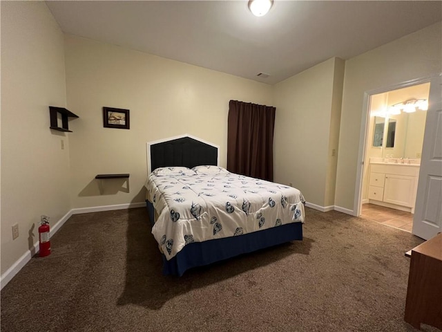 carpeted bedroom with a sink, visible vents, baseboards, and ensuite bathroom