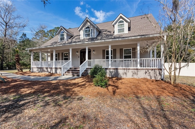 view of front facade with a shingled roof and covered porch