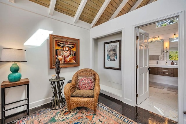 living area featuring lofted ceiling with beams, marble finish floor, wood ceiling, and baseboards