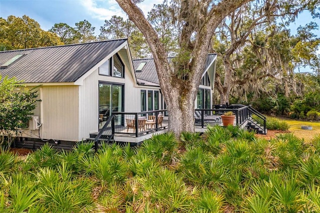 rear view of property featuring metal roof and a wooden deck