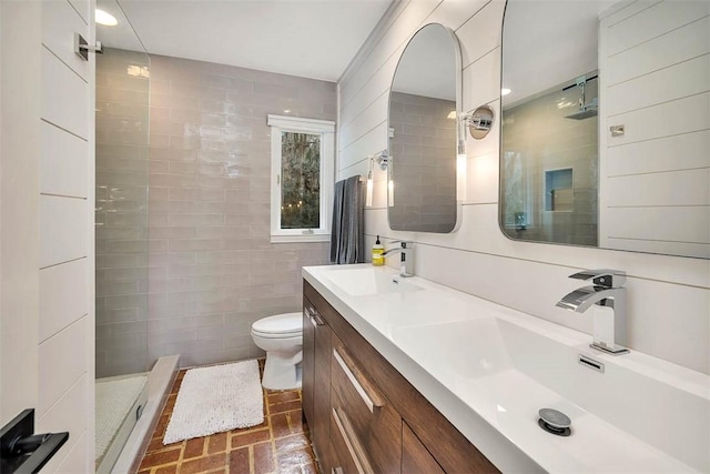 full bathroom with toilet, a sink, tile walls, and a shower stall