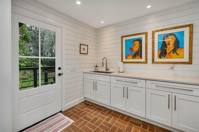 interior space with brick floor, recessed lighting, a healthy amount of sunlight, and a sink