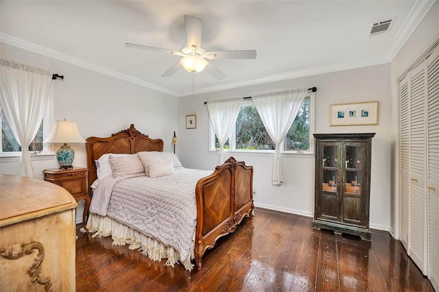 bedroom featuring ornamental molding, a closet, dark wood finished floors, and visible vents