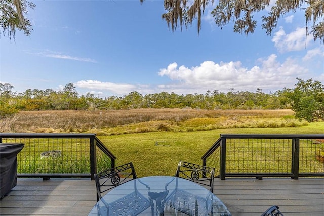 deck with a yard and outdoor dining area