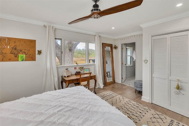 bedroom featuring ornamental molding, a closet, and wood finished floors