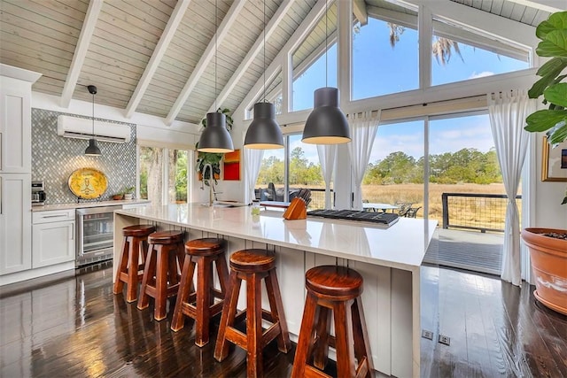 kitchen with dark wood-style flooring, a wall unit AC, tasteful backsplash, white cabinetry, and beverage cooler