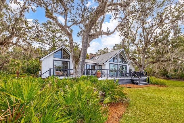 rear view of house with a wooden deck and a yard