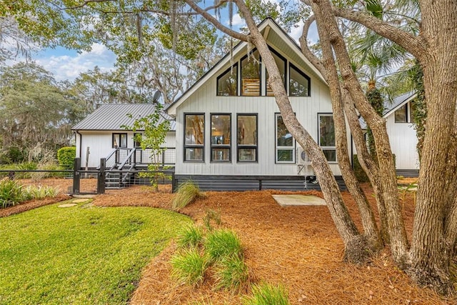 rear view of house featuring fence and a yard