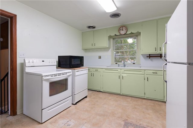 kitchen with white appliances, green cabinets, and sink