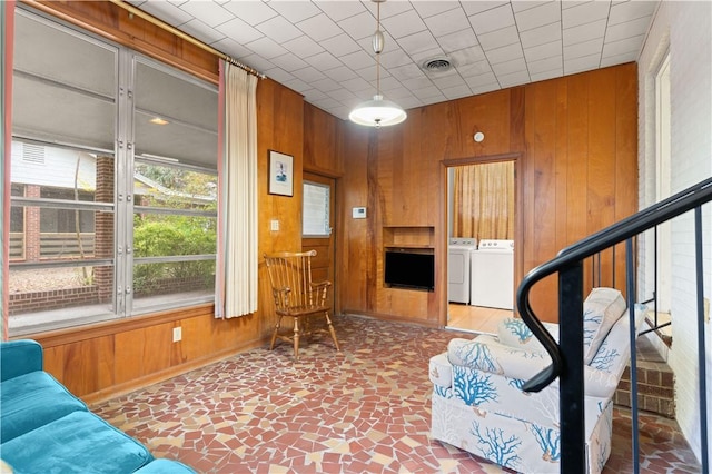 living room featuring washing machine and clothes dryer and wooden walls