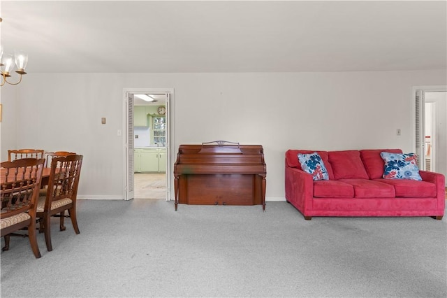 carpeted living room featuring an inviting chandelier