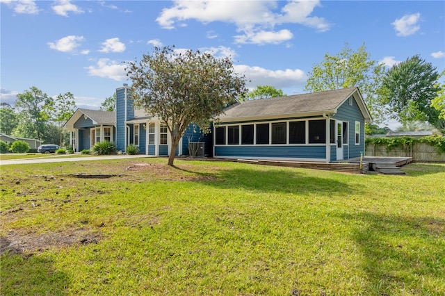 501 W Hall St, Saint Marys, GA 31558 - back of house featuring a lawn, fence, a chimney, and a sunroom