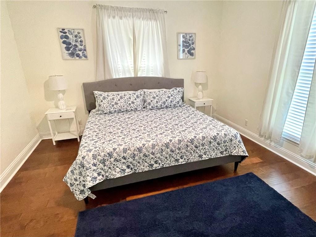 bedroom featuring baseboards and wood finished floors