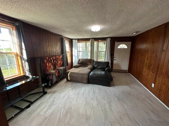 living room with wood walls and a textured ceiling