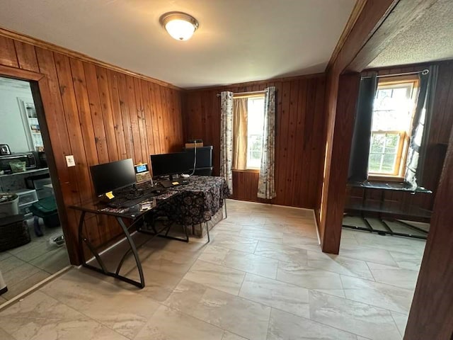 office space with ornamental molding and wood walls