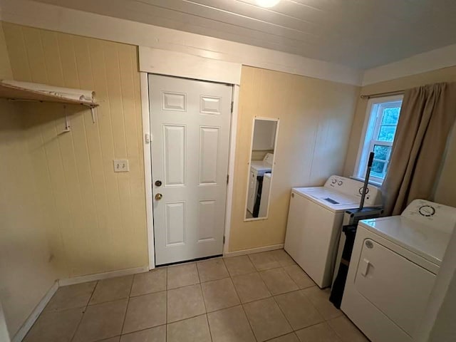 laundry area with separate washer and dryer and light tile patterned flooring