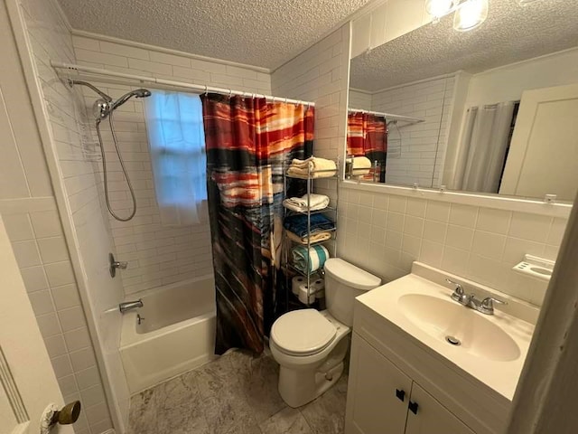 full bathroom featuring tile walls, shower / tub combo with curtain, vanity, and a textured ceiling