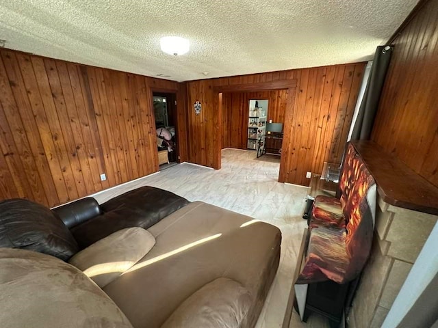 living room featuring a textured ceiling and wood walls