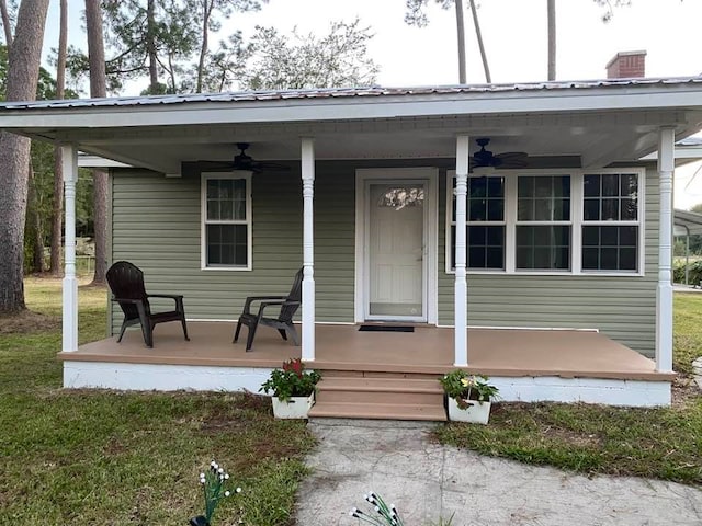 doorway to property featuring covered porch and a yard