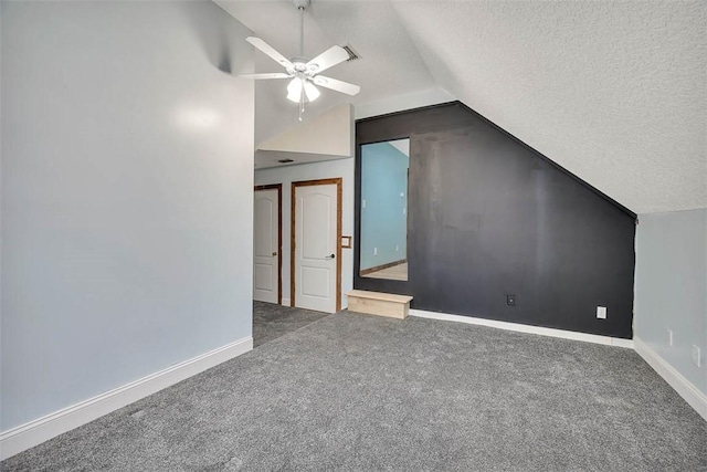 additional living space with carpet, vaulted ceiling, a textured ceiling, and baseboards