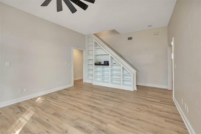 unfurnished living room with light wood finished floors, a ceiling fan, visible vents, and baseboards