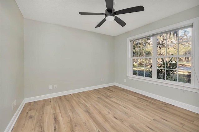 spare room featuring baseboards, a healthy amount of sunlight, and light wood-style floors